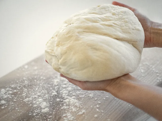 Dough being worked by hand on a floured board